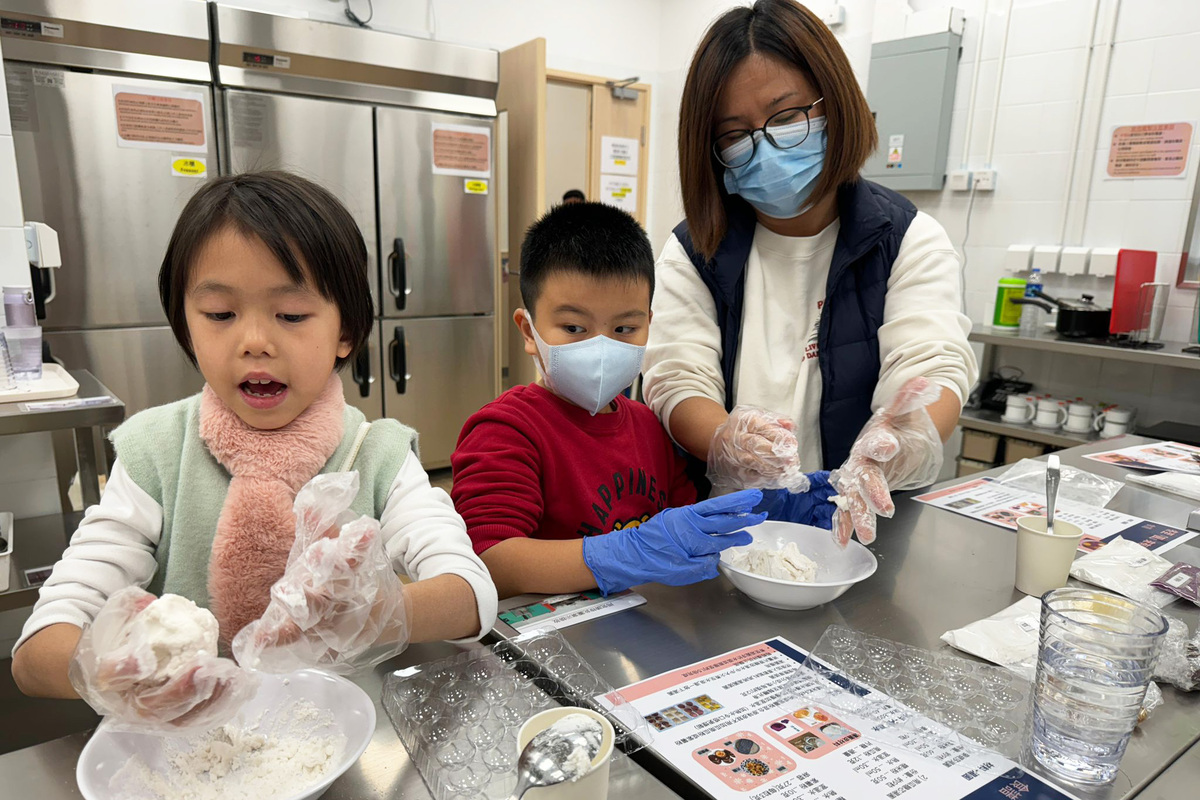 共度佳節:  在剛過去的冬至，梁女士（右）與其他家庭一同在深水埗社區客廳做湯圓應節。（九龍樂善堂提供）