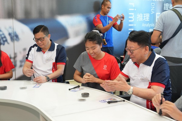 體驗學習: 陳國基(右)和鄧炳強(左)與少訊會員參與指模鑑證工作坊。