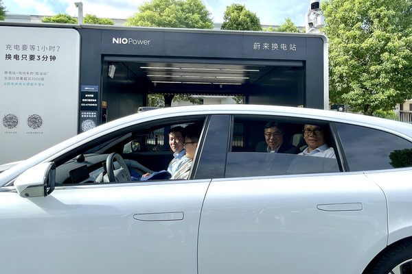 智慧出行: 林世雄(右二)在上海一間智能電動汽車公司了解電動汽車的換電過程。