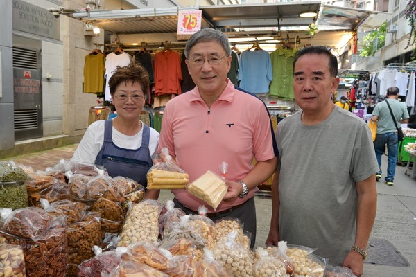 分享喜悅: 卓永興（中）與參與慶祝國慶購物優惠的涼果商販合照。