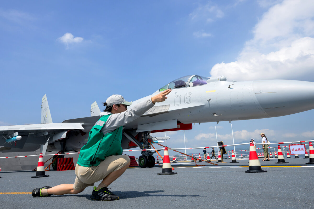 夢想成真:  參觀者試穿工作服，想像自己成為航母人員。