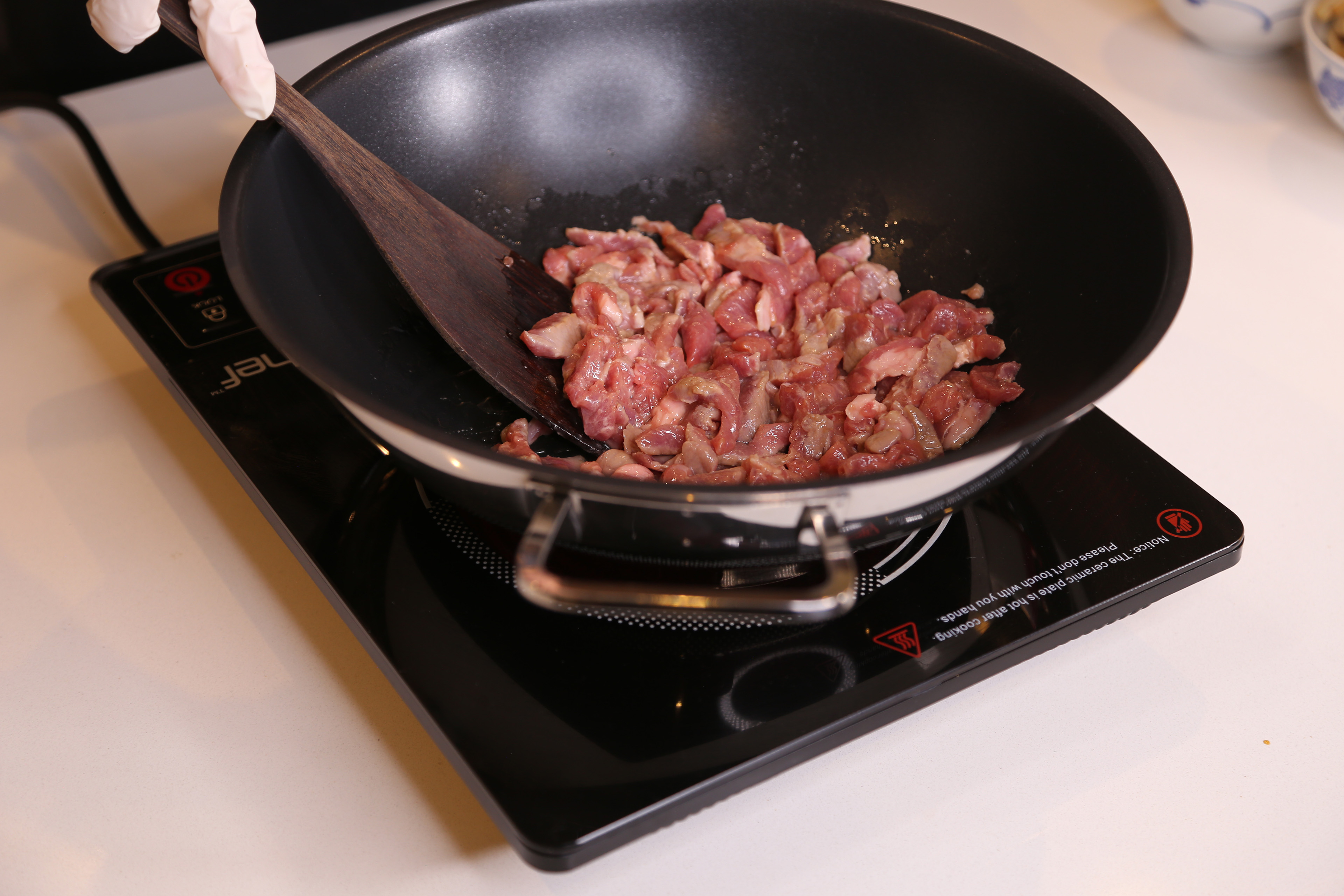 2. 大火下油落鑊，加入豬肉炒至8-9分熟盛起備用