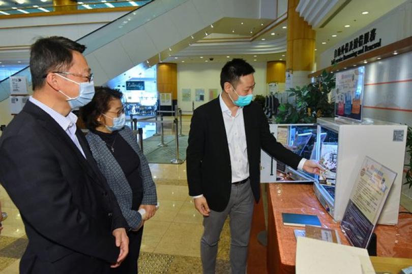 重開在即:  徐英偉（右）到訪香港中央圖書館，試用自助圖書紫外線除菌機。