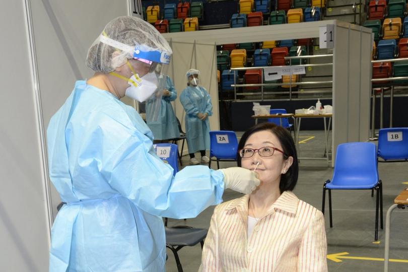 踴躍參與:  陳漢儀（右）視察設於灣仔伊利沙伯體育館的社區檢測中心，並即場接受採樣。