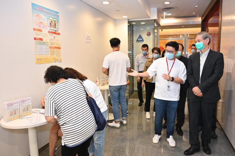 申請首日:  羅致光（右一）與銀行職員交談，了解他們接受低收入家庭新來港定居成員申請一次過津貼的情況。