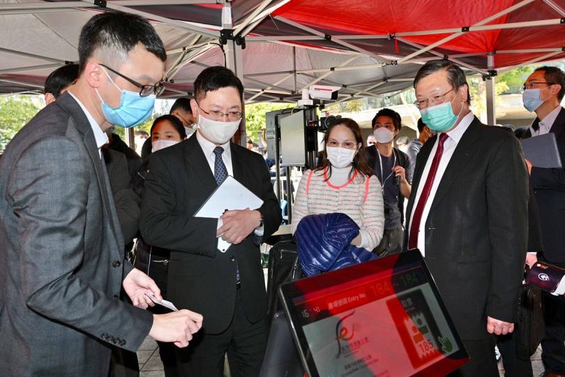 監察人流:  薛永恒（左二）在維多利亞公園視察年花銷售點應用科技監察人流的準備情況，並聽取輪候和派籌機制的安排。