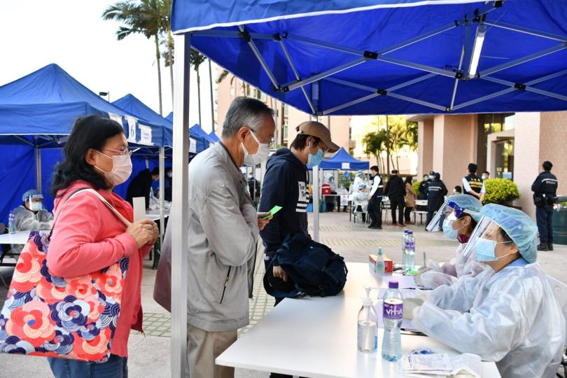 攜手抗疫:  政府在屯門指明受限區域的限制與檢測宣告和執法行動完成，工作人員檢查受限人士是否已接受強制檢測。