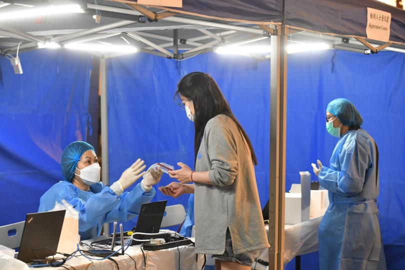 強制檢測:  政府在深水埗設受限區域，工作人員為受檢人士登記進行檢測。