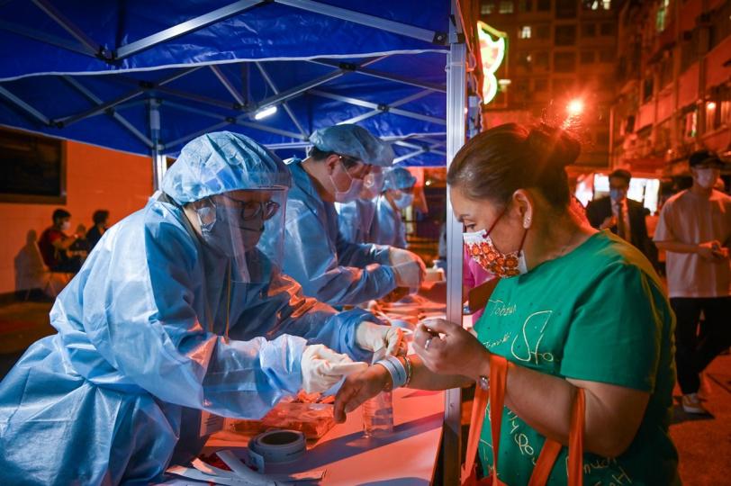 檢測證明:  政府在新蒲崗設受限區域，工作人員為受檢人士戴上手環，證明已接受檢測。