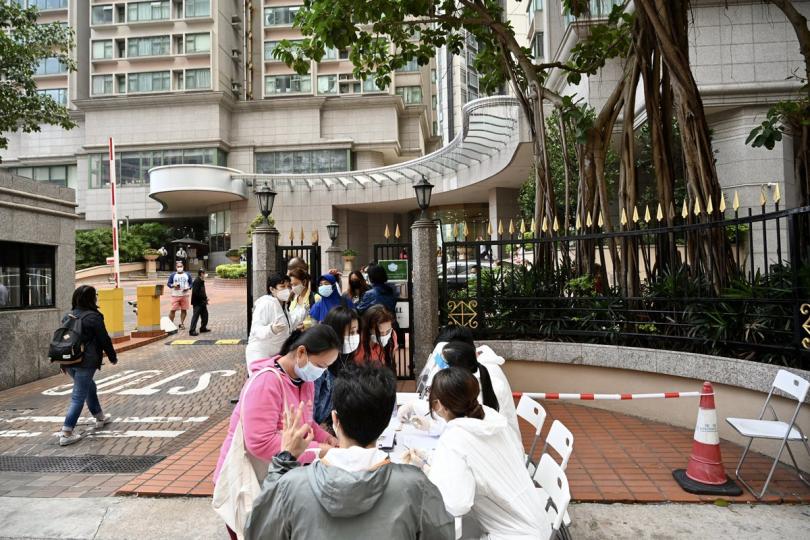 逐一檢查:  工作人員在中西區指明受限區域檢查受限人士是否已接受強制檢測。