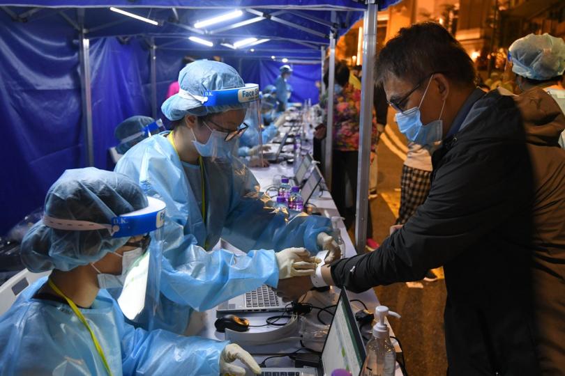 以資識別:  工作人員在中西區指明受限區域為受檢人士戴上手環，識別已接受檢測人士。