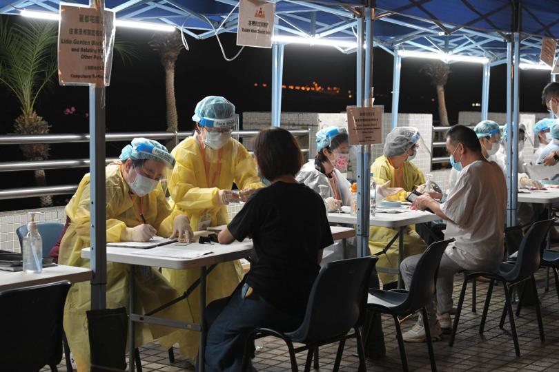 有序受檢:  工作人員在荃灣受限區域內為受檢人士登記進行檢測。