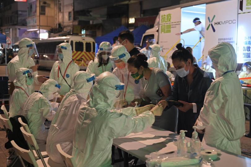 一絲不苟:  工作人員在佐敦受限區域內為受檢人士登記進行檢測。