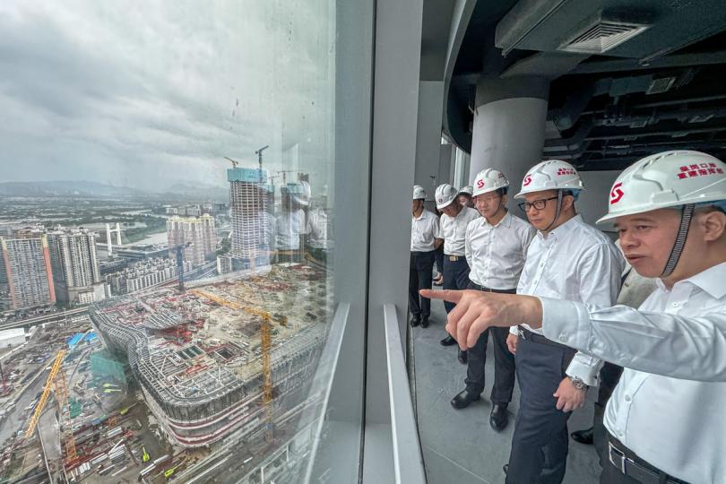 進展順暢:  鄧炳強（右二）在皇崗口岸綜合業務樓實地調研，了解工程進展。