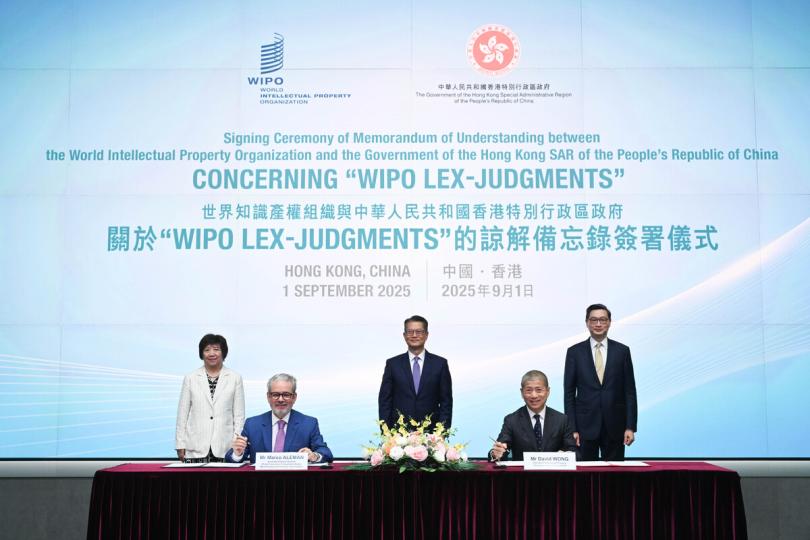 資訊共享:  陳茂波（後排中）、王彬穎（後排左）和潘兆初（後排右）見證黃福來（前排右）和馬爾科．阿萊曼簽署諒解備忘錄。